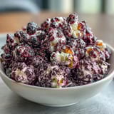 Gourmet kettle corn drizzled with black currant essence and cheesecake powder, offering a sweet and tangy popcorn treat.  