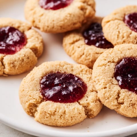 Freshly baked Thumbprint Cookies offering a delightful mix of buttery shortbread and fruity preserves.