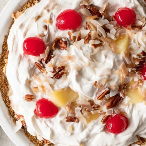 A slice of chilled Millionaire Pie, a no-bake dessert bursting with fruit and coconut flavors.
