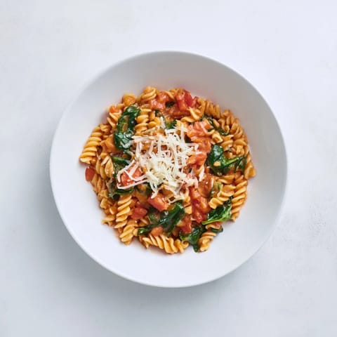 One-pot Tomato Spinach One-Pot Rotini with melted Parmesan, fresh basil, and a sprinkle of red pepper flakes for a cozy Italian dinner.  