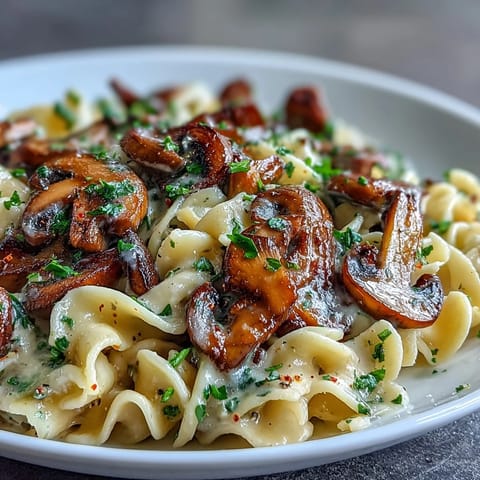 A close-up of the rich, creamy pasta with savory sautéed mushrooms and herbs.  