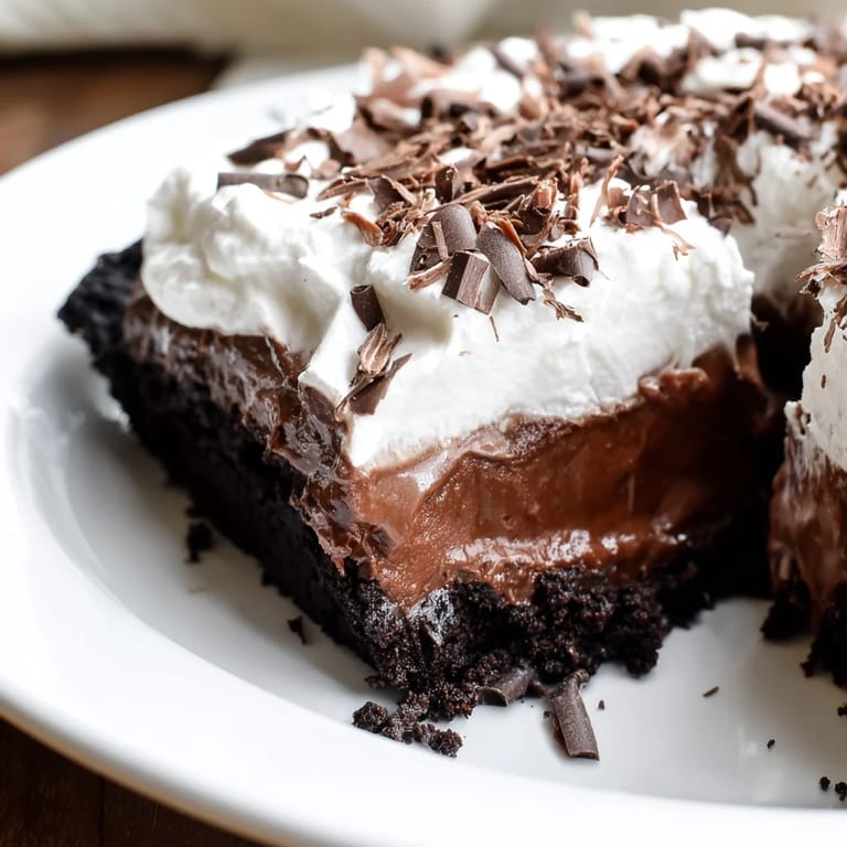 Garnished Mississippi Mud Pie, a perfect dessert, showcasing the fudgy chocolate layers and whipped cream topping.