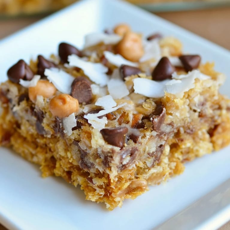 Chewy, delicious Magic Cookie Bars displayed with a buttery graham cracker crust and toppings.
