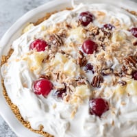 Creamy Millionaire Pie with cherries, pineapple, and pecans, ready to serve cold for dessert.