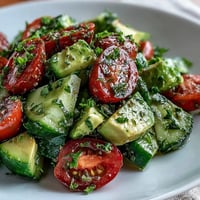 Fresh cucumber tomato avocado salad with lemon dressing, a vibrant and healthy vegetarian dish perfect for summer.  